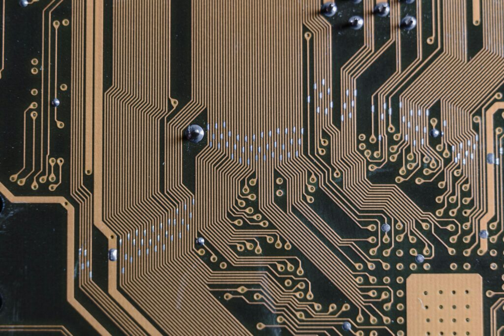 An almost black circuit board with bright gold wires and silver sauter